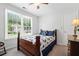 Bedroom with a window view, carpeted floor, and a wood bedframe with blue pillows and a floral quilt at 1126 Gate Post Ct, Powder Springs, GA 30127
