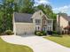 Inviting two-story home with a manicured lawn, stone accents, and a two-car garage at 1126 Gate Post Ct, Powder Springs, GA 30127