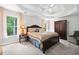 Main bedroom with a tray ceiling, carpet, large window and a dark wooden dresser at 1126 Gate Post Ct, Powder Springs, GA 30127