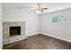 Spacious room with a stone fireplace, hardwood floors, a ceiling fan and a bright window at 1281 Snapfinger Rd, Decatur, GA 30032
