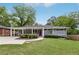 Charming one-story home with a landscaped front yard, carport, and inviting purple front door at 1281 Snapfinger Rd, Decatur, GA 30032