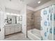 Well-lit bathroom features double sinks, a tub, and shower with tile surround at 2450 Norwood Park Xing, Atlanta, GA 30340