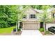 Charming two-story home with a brick facade and an attached two-car garage surrounded by mature trees at 2450 Norwood Park Xing, Atlanta, GA 30340