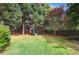 Spacious backyard featuring a playset, mature trees, and green lawn at 26 Clarendon Ave, Avondale Estates, GA 30002