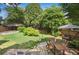 Expansive backyard with patio, dining set, and play area, framed by mature trees and lush lawn at 26 Clarendon Ave, Avondale Estates, GA 30002