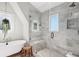 This bathroom features a glass shower, soaking tub, marble tile, patterned floor, and bright natural light at 26 Clarendon Ave, Avondale Estates, GA 30002