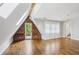 Sunlit bedroom boasts hardwood floors, a skylight, wood accent wall, and a view into the en-suite bath at 26 Clarendon Ave, Avondale Estates, GA 30002