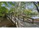 Scenic view of a wooden bridge leading to a gazebo on a lake with lush greenery at 26 Clarendon Ave, Avondale Estates, GA 30002