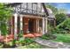 Close up of inviting front porch, featuring red brick, white columns, and lush landscaping at 26 Clarendon Ave, Avondale Estates, GA 30002