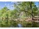 A reflective lake view showcases the surrounding lush greenery and clear blue sky at 26 Clarendon Ave, Avondale Estates, GA 30002