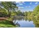Picturesque lake view with serene water, lush trees, and a charming swing on the grassy bank at 26 Clarendon Ave, Avondale Estates, GA 30002