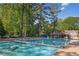 Large community pool surrounded by lush greenery and a charming Tudor-style clubhouse at 26 Clarendon Ave, Avondale Estates, GA 30002