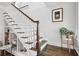 Elegant staircase features a dark-stained wood handrail, white balusters, and custom built-in shelving underneath at 26 Clarendon Ave, Avondale Estates, GA 30002