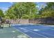 Well-maintained community tennis court surrounded by mature trees and a secure fence at 26 Clarendon Ave, Avondale Estates, GA 30002