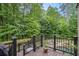 Backyard deck view showcasing an inviting pool and lush greenery beyond the black railings, creating a serene retreat at 351 Old Orchard Ct, Marietta, GA 30068