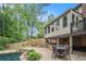 Outdoor patio area with dining set and grilling station overlooking a beautiful pool and landscaped backyard at 351 Old Orchard Ct, Marietta, GA 30068
