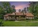 Charming home with stone accents, dormer windows, a lush lawn, and mature landscaping at sunset at 351 Old Orchard Ct, Marietta, GA 30068