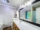 Bright bathroom featuring a large mirror, vanity with marble countertop and cabinet storage at 505 Blake Dr, Douglasville, GA 30134