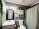This bathroom features a shower with decorative curtain, neutral wall paneling, and hanging storage at 505 Blake Dr, Douglasville, GA 30134