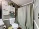 This bathroom features a shower with a decorative curtain, neutral wall paneling, and tile floor at 505 Blake Dr, Douglasville, GA 30134