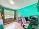 This is a playful bedroom area with light wood floor and a gray and turquoise painted wall at 505 Blake Dr, Douglasville, GA 30134