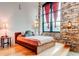 Bedroom with brick walls and high ceilings shows a bed with large windows and hardwood floors at 170 Boulevard # H201, Atlanta, GA 30312