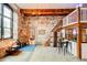 Open-concept living space with exposed brick, wood beams, and dining area at 170 Boulevard # H201, Atlanta, GA 30312