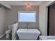 Modern bathroom with square soaking tub, toilet, and decorative lighting fixture at 1740 Emerald Ave Ave, Atlanta, GA 30310