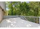 A spacious, light-colored back deck overlooks lush greenery, offering serene outdoor living and entertaining space at 3445 Strawberry Ln, Cumming, GA 30041
