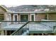 A back deck on a brick home boasts an outdoor living space with stairs leading to a verdant backyard at 3445 Strawberry Ln, Cumming, GA 30041