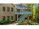 Elevated view of the back of a brick home with stairs and deck overlooking a green lawn at 3445 Strawberry Ln, Cumming, GA 30041