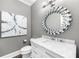 Stylish powder room featuring an artistic mirror, marble vanity, and modern lighting at 3445 Strawberry Ln, Cumming, GA 30041