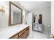 Bright bathroom featuring a wooden vanity, ornate mirror, and neutral walls, creating a clean and inviting space at 3445 Strawberry Ln, Cumming, GA 30041