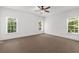 Bright bedroom featuring neutral carpet, a ceiling fan, and lots of natural light from the three windows at 3445 Strawberry Ln, Cumming, GA 30041