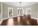 This elegant dining room features wainscoting, a modern chandelier, and large windows for natural light at 3445 Strawberry Ln, Cumming, GA 30041