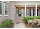 Inviting front entrance with black door, white columns, and landscaped garden at 3445 Strawberry Ln, Cumming, GA 30041