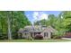 Charming brick home with lush landscaping, mature trees, and a well-manicured lawn at 3445 Strawberry Ln, Cumming, GA 30041