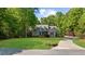 Charming brick home with manicured lawn, mature trees, and a curved driveway at 3445 Strawberry Ln, Cumming, GA 30041
