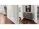 Hallway featuring hardwood floors, access to the staircase, and a decorative cabinet with art at 3445 Strawberry Ln, Cumming, GA 30041