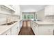 Bright kitchen with white cabinets, quartz countertops, and stainless steel appliances overlooking the backyard at 3445 Strawberry Ln, Cumming, GA 30041