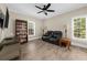Cozy living room with a leather sofa, ceiling fan, and built-in shelving unit at 3445 Strawberry Ln, Cumming, GA 30041