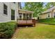 Exterior view of the screened-in porch and wood deck surrounded by a lush green lawn and landscaping at 1552 Brentwood Dr, Marietta, GA 30062