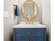 Stylish powder room featuring a gold mirror and fixtures, with a blue vanity at 1552 Brentwood Dr, Marietta, GA 30062