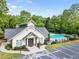 Exterior shot of a community clubhouse with ample parking, surrounded by lush trees and a sparkling pool at 1552 Brentwood Dr, Marietta, GA 30062
