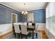 Dining room with an elegant chandelier, wallpaper, white wainscotting, and a large window at 1552 Brentwood Dr, Marietta, GA 30062