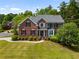 Beautiful two-story brick home with a manicured lawn, lush greenery, and charming curb appeal at 1552 Brentwood Dr, Marietta, GA 30062