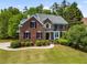 Beautiful two-story brick home with a manicured lawn, lush greenery, and charming curb appeal at 1552 Brentwood Dr, Marietta, GA 30062
