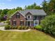 Beautiful two-story brick home with a manicured lawn, lush greenery, and charming curb appeal at 1552 Brentwood Dr, Marietta, GA 30062