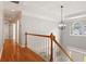 Hallway featuring hardwood floors, an elegant light fixture, and an arched window at 1552 Brentwood Dr, Marietta, GA 30062