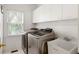 Convenient laundry room with modern washer and dryer, sink, and storage cabinets at 1552 Brentwood Dr, Marietta, GA 30062